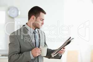 Businessman drinking tea while reading the news