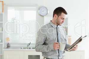 Young businessman reading the news while having breakfast