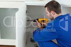 Young handyman fixing a door