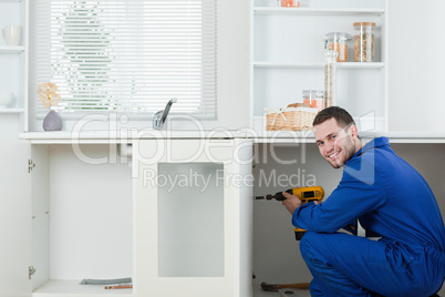 Smiling handyman fixing a door