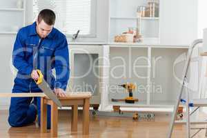 Young handyman cutting a wooden board
