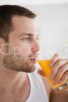 Close up of a young man drinking orange juice
