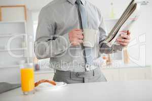 Businessman holding a newspaper while having breakfast