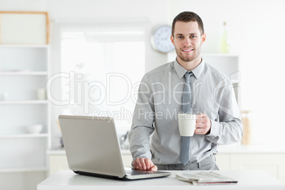 Businessman using a notebook while drinking coffee