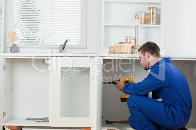 Good looking handyman fixing a door