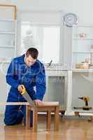 Portrait of a handsome handyman cutting a wooden board