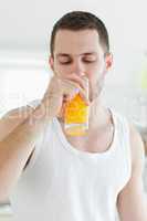 Portrait of an attractive man drinking orange juice