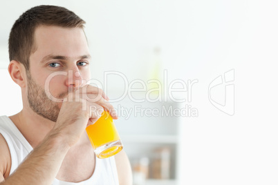 Portrait of a good looking man drinking orange juice
