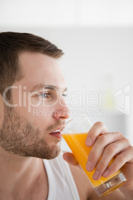 Close up of a man drinking orange juice