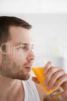 Close up of a man drinking orange juice