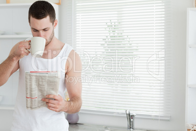 Man drinking tea while reading the news