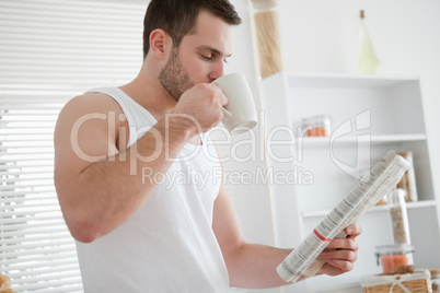 Young man drinking coffee while reading the news