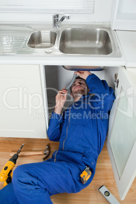 Portrait of a smiling plumber fixing a sink