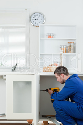 Portrait of a handsome handyman fixing a door