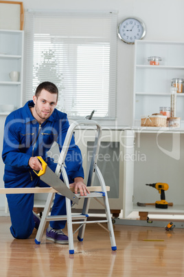 Portrait of a handyman cutting a wooden board
