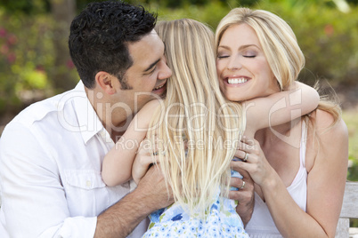 Girl Child Hugging Happy Parents In Park or Garden