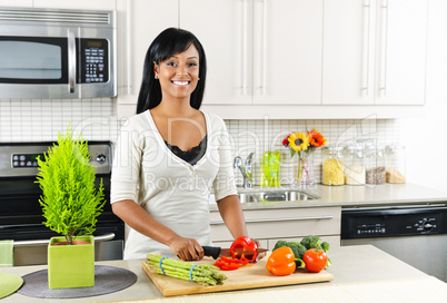 Young woman cutting vegetables in kitchen