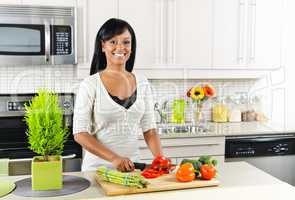 Young woman cutting vegetables in kitchen