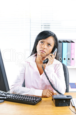 Concerned black businesswoman on phone at desk