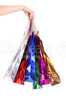 Female hand holding colorful shopping bags isolated