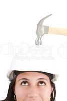 girl with safety helmet about to be hit by a hammer over a white