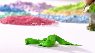 Paintbrush mixing green paint