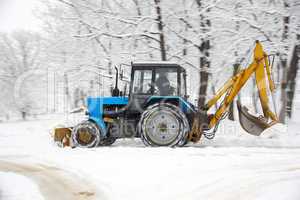 Tractor removes snow in a park