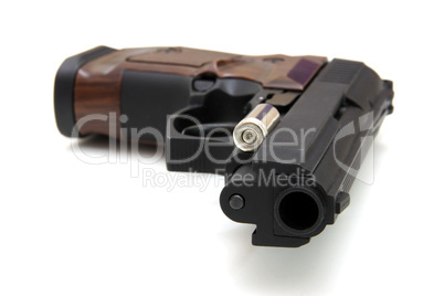 The close up of a pistol a target and cartridges is isolated on