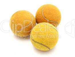 Three old tennis balls on a white background