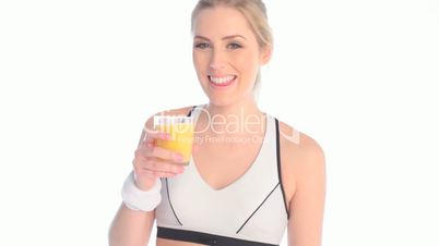 blonde fitness woman drinking orange juice after workout
