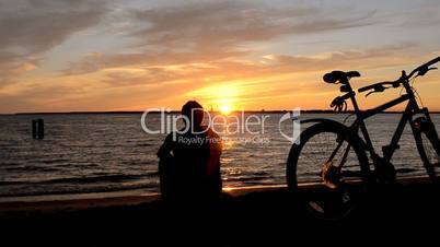 Man and Bicycle on the coast at sunset