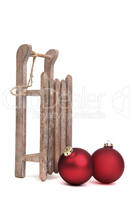 old wooden sledge with two christmas baubles