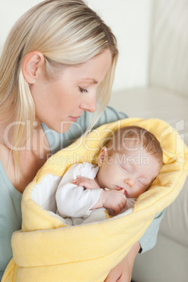 Mother looking at her cute baby in her arms