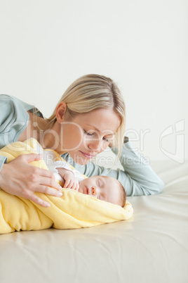 Mother lying next to her sleeping baby