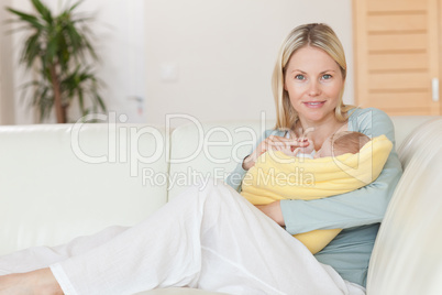 Mother sitting on the couch holding her baby in her arms