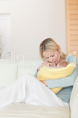 Mother sitting on the couch holding her baby close