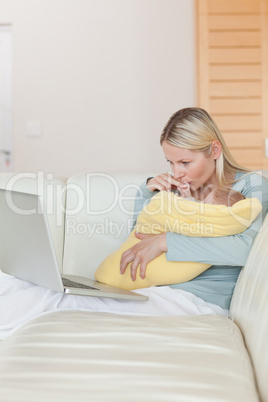 Mother looking at her laptop while holding her baby