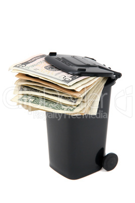 batch of bank notes in black rubbish bin on white
