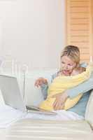 Mother on the couch showing her baby something on the laptop