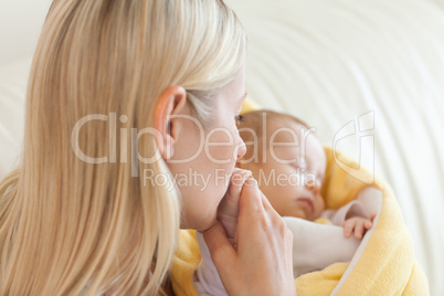 Above view of mother kissing her baby's hand