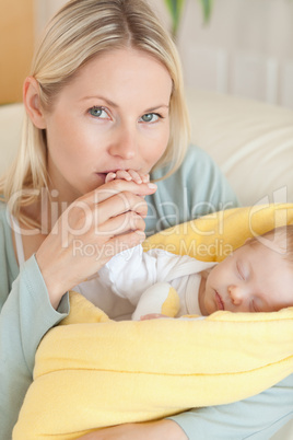 Close up of affectionate mother kissing her baby's hand