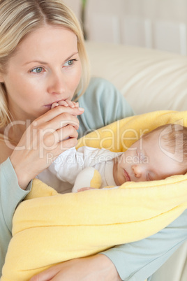 Close up of provident mother kissing her baby's hand