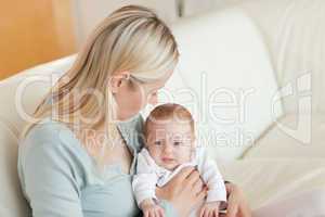 Mother on the sofa with her newborn on her lap