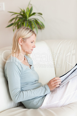 Side view of woman reading on her sofa