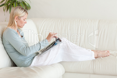Side view of woman reading on her couch