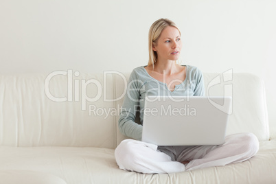 Woman sitting cross legged on the couch with her laptop