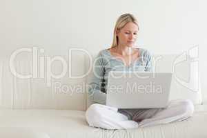 Woman sitting cross legged on the couch with her notebook