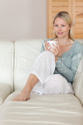 Woman on the sofa relaxing with a cup of coffee