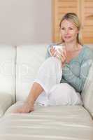 Woman on the sofa relaxing with a cup of coffee