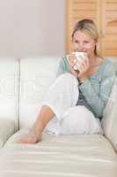 Woman taking a sip of coffee on the sofa